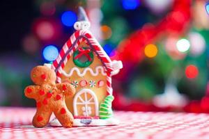 söt pepparkaka man och godis ingefära hus bakgrund jul träd lampor foto