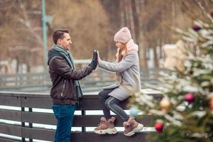 ung pappa och förtjusande liten flicka ha roligt på skridskoåkning rink utomhus foto