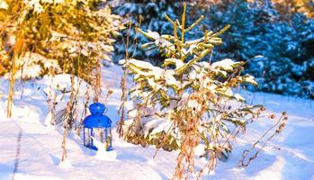 skön blå lykta med en ljus på vit snö utomhus- foto