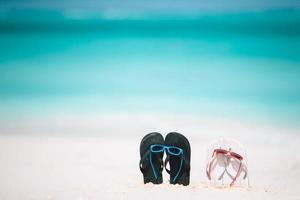 sommar flip flops med solglasögon på vit strand. närbild strand Tillbehör. foto