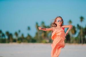 Fantastisk liten flicka på strand har en massa av roligt på sommar semester. foto