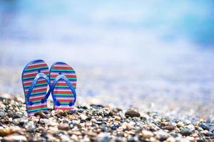 barn flip flops på strand i främre av de hav foto