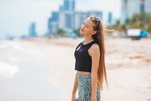 Lycklig ung flicka njut av tropisk strand semester foto