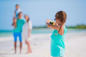 liten flicka gör foto på telefonen av familjen på stranden