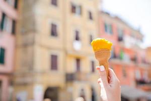 välsmakande ljuv glass närbild i kvinna händer bakgrund gammal italiensk by foto