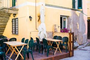 tömma öppen luft Kafé med färgrik tabeller på italiensk gammal by i cique terre foto