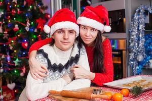 porträtt av ung Lycklig par bakning jul kakor på Hem foto
