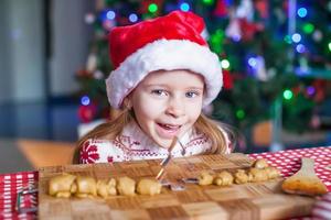 rolig liten flicka bakning jul pepparkaka småkakor foto