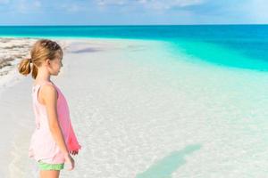 Fantastisk liten flicka på strand har en massa av roligt på sommar semester. närbild profil av unge på tropisk havsstrand foto