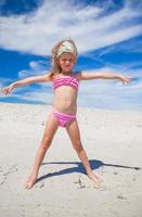 förtjusande liten flicka i skön baddräkt ha roligt på tropisk strand foto