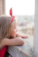 förtjusande liten flicka på de taket av Duomo, milano, Italien foto