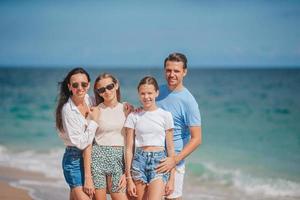 Lycklig familj på de strand under sommar semester foto