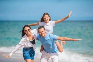 Lycklig familj av tre på de strand under sommar semester foto