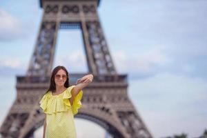 ung kvinna framställning selfie - själv porträtt förbi telefon bakgrund eiffel torn i paris foto