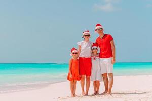 Lycklig familj med två barn i santa hatt på sommar semester foto