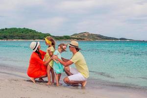 Lycklig familj på de strand under sommar semester foto