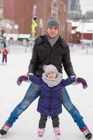 Lycklig familj på skridskoåkning rink utomhus foto