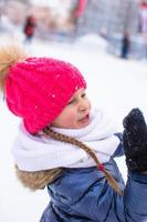 förtjusande liten flicka utomhus- i de parkera på vinter- dag foto