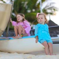 förtjusande liten flickor ha roligt på vit strand under semester foto