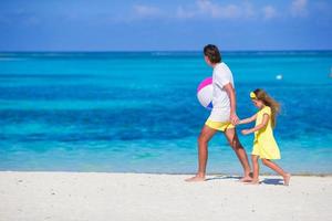 Lycklig far och dotter spelar med boll utomhus- på strand foto