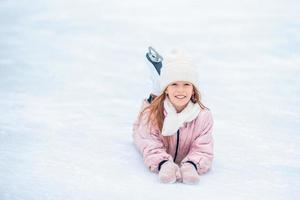 porträtt av liten förtjusande flicka i snö solig vinter- dag foto