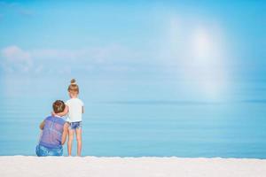 skön mor och dotter på de strand njuter sommar semester. foto