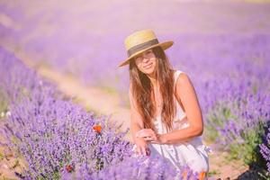 kvinna i lavendel- blommor fält i vit klänning och hatt foto