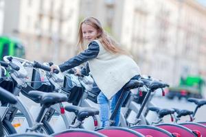 förtjusande flicka ridning en cykel i de stad foto