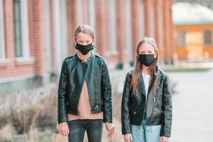 flickor bär en mask på en bakgrund av en modern byggnad, foto