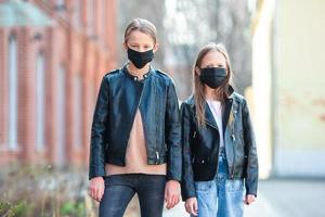flickor bär en mask på en bakgrund av en modern byggnad, foto