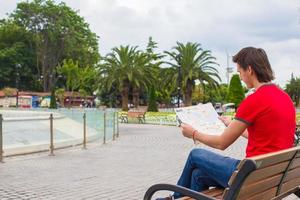 man med stad Karta på en resa medan gående på sommar semester foto