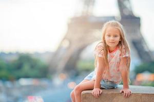 förtjusande litet barn flicka i paris bakgrund de eiffel torn under sommar semester foto