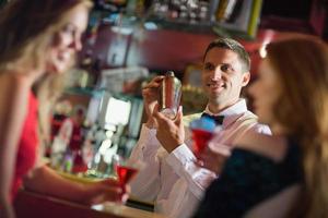 stilig bartender som chattar med kunderna foto