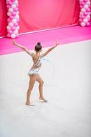 liten gymnast Träning på de matta och redo för tävlingar foto