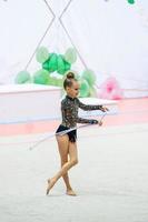 liten gymnast Träning på de matta och redo för tävlingar foto