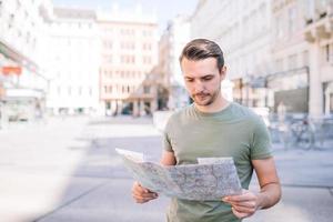 man turist med en stad Karta och ryggsäck i Europa gata. foto