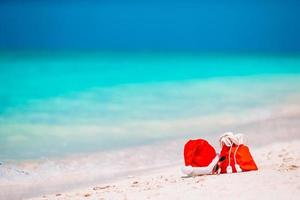 Tillbehör med santa hatt på vit tropisk strand foto