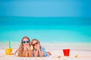 liten flickor på de strand under sommar semester foto