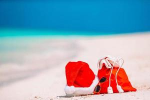 Tillbehör med santa hatt på vit tropisk strand foto