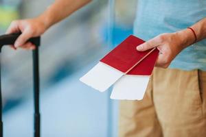 närbild av man som håller pass och boardingkort på flygplatsen foto