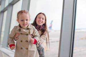 mor och liten flicka i flygplats väntar för ombordstigning foto