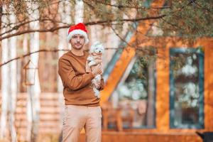 ung man i santa hatt bakgrund av trä hus foto