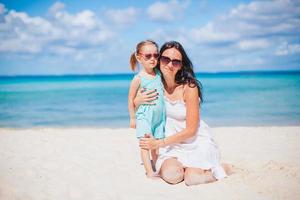 skön mor och dotter på de strand njuter sommar semester foto