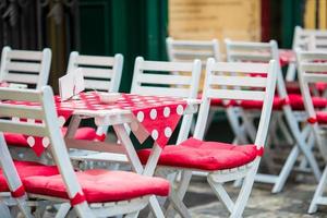 vit trä- tabeller med stolar på sommar öppen luft Kafé terrass. se av tömma utomhus- Kafé i Europa. foto