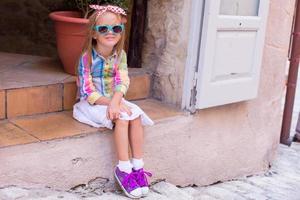 förtjusande liten flicka i utomhus Kafé i europeisk stad foto