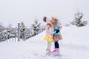 förtjusande flickor skridskoåkning på is rink utomhus i vinter- snö dag foto