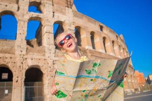 förtjusande liten aktiva flicka med Karta i främre av colosseum i rom, Italien. unge utgifterna barndom i Europa foto