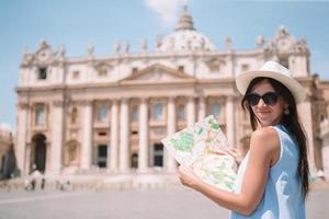 Lycklig ung kvinna med stad Karta i vatican stad och st. peters basilika kyrka foto