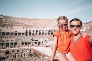 Lycklig familj i rom över coliseum bakgrund foto