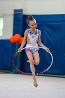 liten gymnast Träning på de matta och redo för tävlingar foto